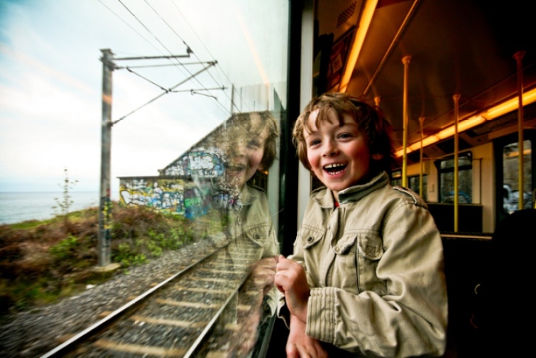 Egy vidám kisfiú utazik a vonaton 