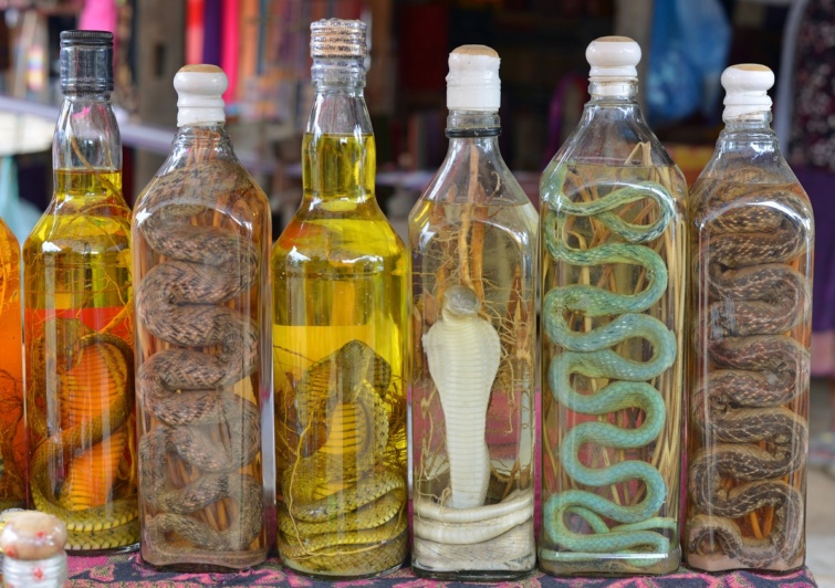Egymás mellett sorakozó kígyóboros flaskák Laoszban.