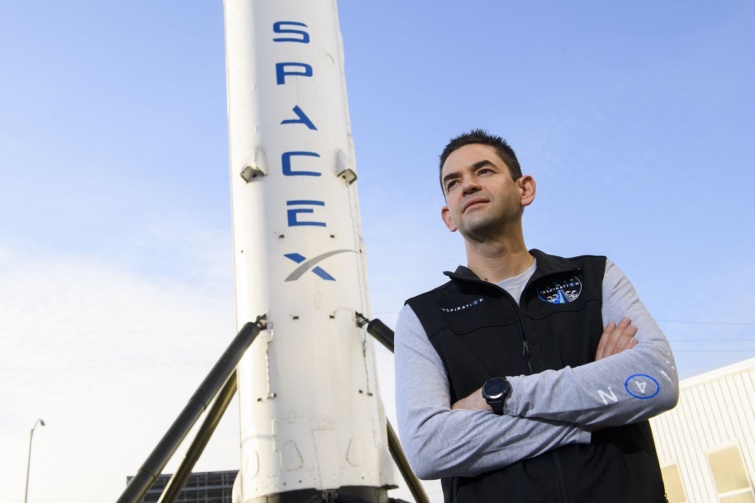 Jared Isaacman a Space X Falcon 9 űrhajója előtt pózol.