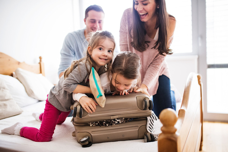 Gyerekek a szüleikkel egy bőröndöt csomagolnak be