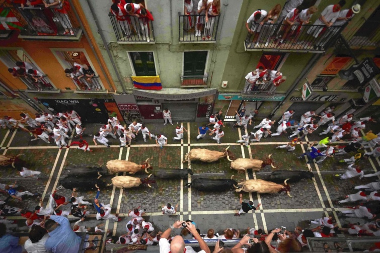 Bikák elõl menekülnek résztvevők a pamplonai San Fermín fesztivál második napján, 2018. július 8-án.