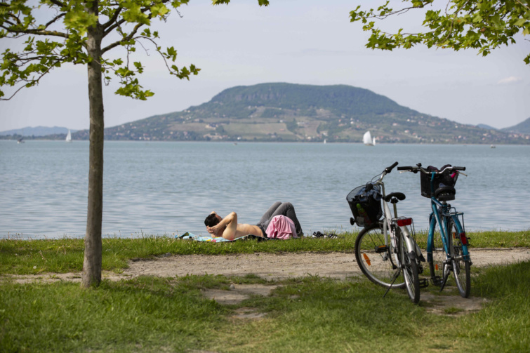 Férfi napozik a Balaton partják - kerékpáros központ Füreden