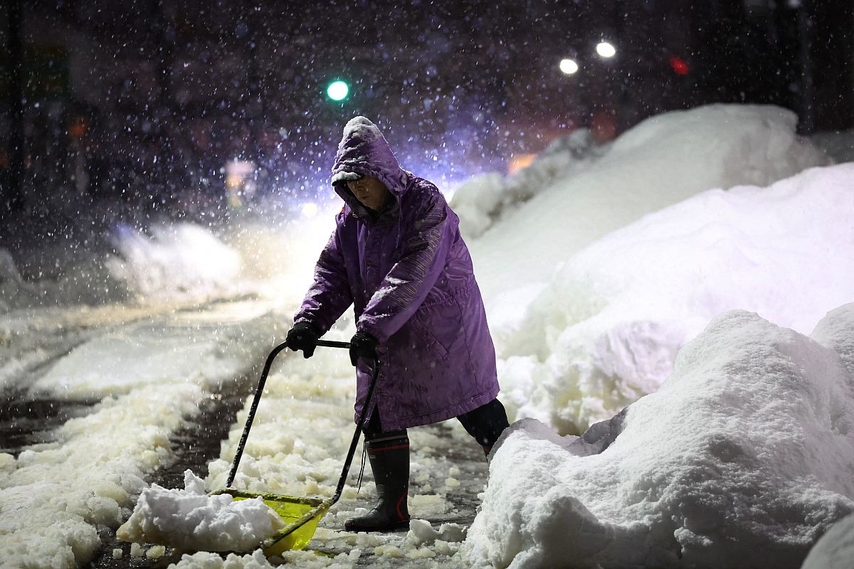Egy férfi havat lapátol Nagaoka egyik utcáján.
