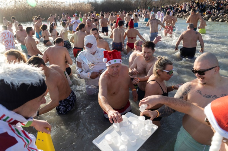 Vella Zsolt polgármester pálinkával kínálja az ábrahámhegyi strandon rendezett fürdőzés résztvevőit 2022. december 31-én. Az Ábrahámhegy SE kilencedik alkalommal rendezte meg az óévbúcsúztató fürdőzést a helyi önkormányzat, vállalkozók, borosgazdák és magánszemélyek támogatásával. Az eseményen több mint százan vettek részt.