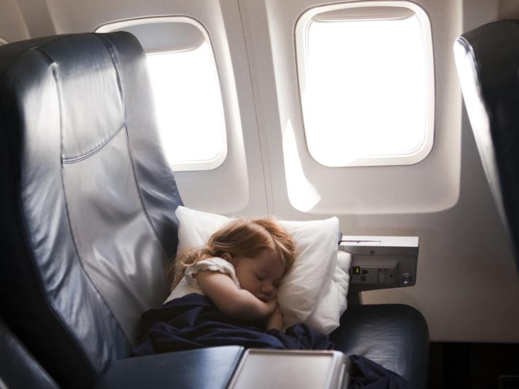 Repülőn alvó kislány