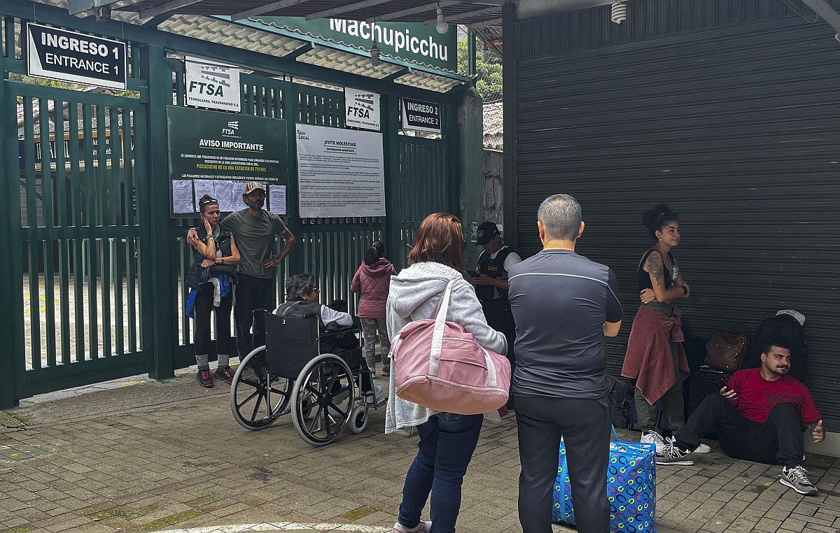 Turisták a Machu Picchu vonatállomás bezárt bejáratánál.