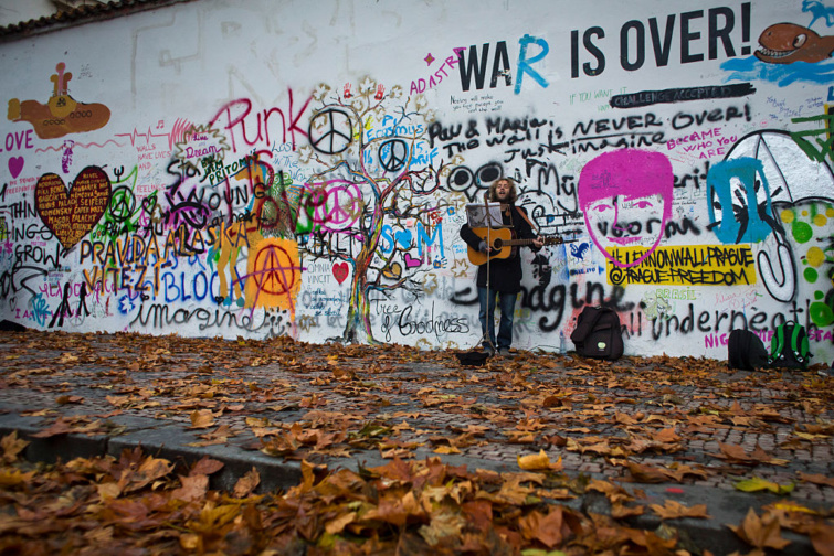 Zenész gitározik és énekel a prágai John Lennon fal előtt 