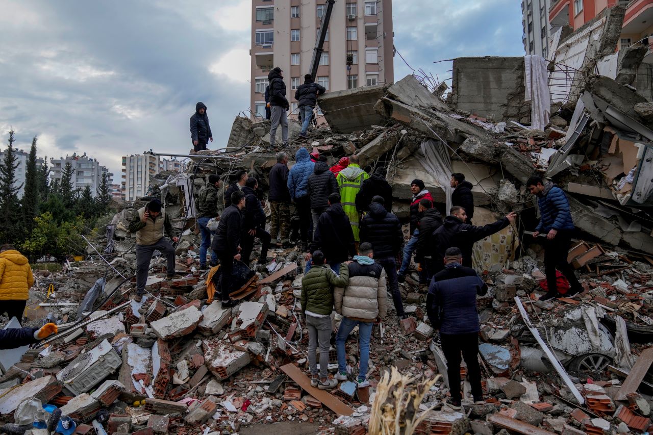 Túlélők és áldozatok után kutatnak egy összedőlt épület törmeléke közt a dél-törökországi Adana nagyvárosban 2023. február 6-án a nagy török-szíriai földrengés után.