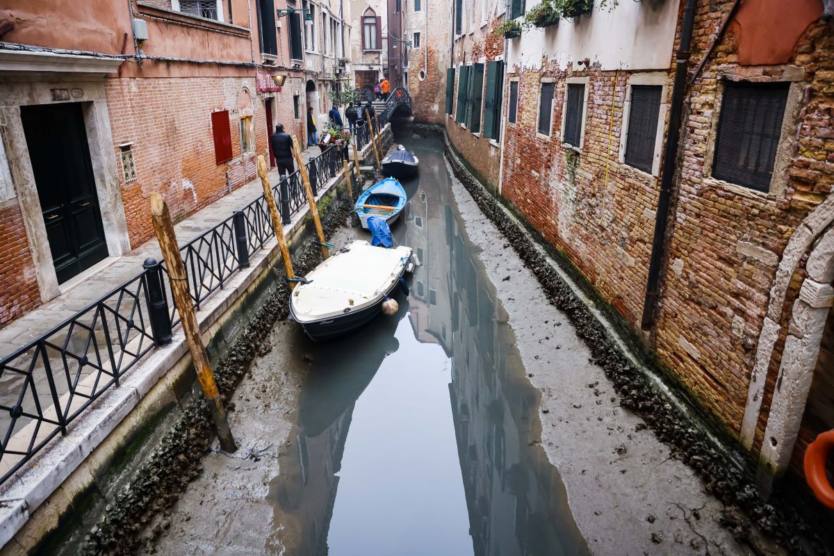 Kiszáradt csatorna és annak oldalában fekvő hajók Velencében