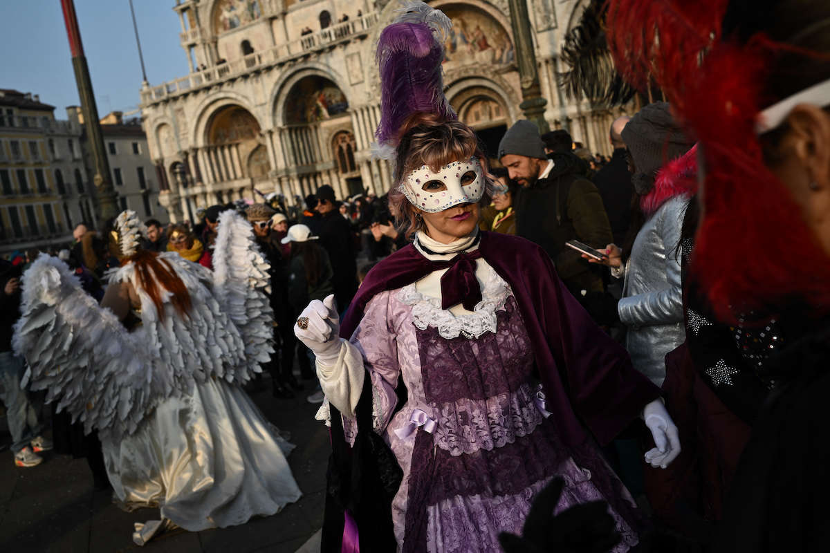 Maszkot és jelmezt viselők vonulnak fel a Szent Márk téren a Velencei Karnevál alkalmával