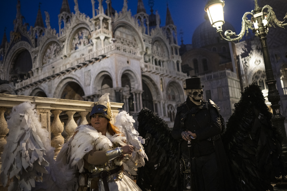 Jelmezes emberek vonulnak fel a Szent Márk téren a Velencei Karnevál alkalmával