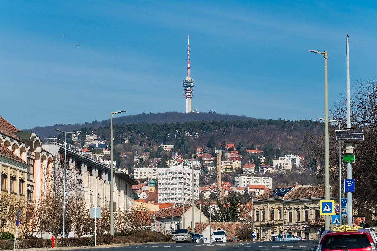 Pécsi belváros egyik utcájának látképe, a háttérben pedig, a 197 méter magas tévétorony a Mecsekben