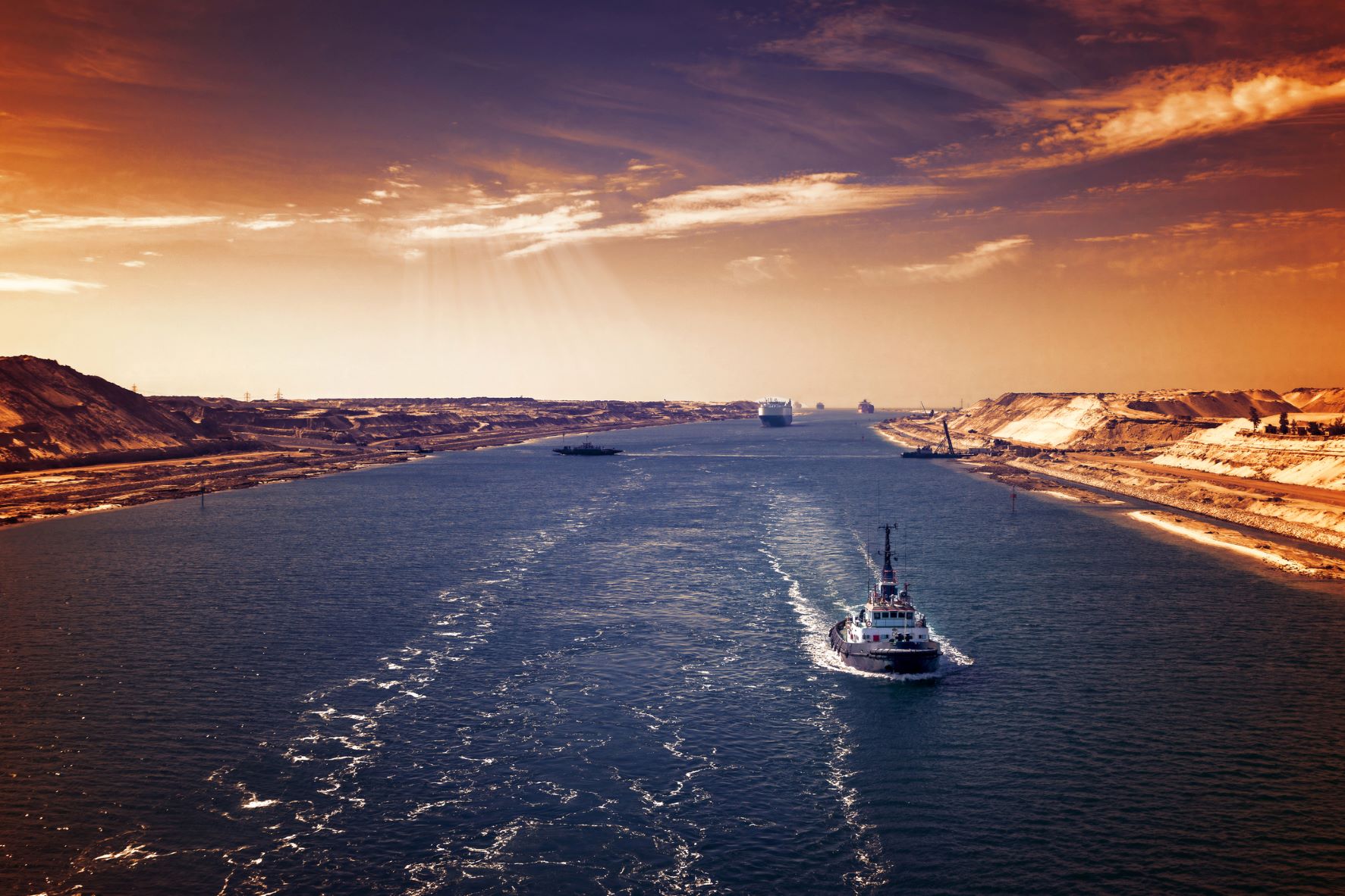 Hajókonvoj közlekedik a Szuezi-csatornán esti fényben