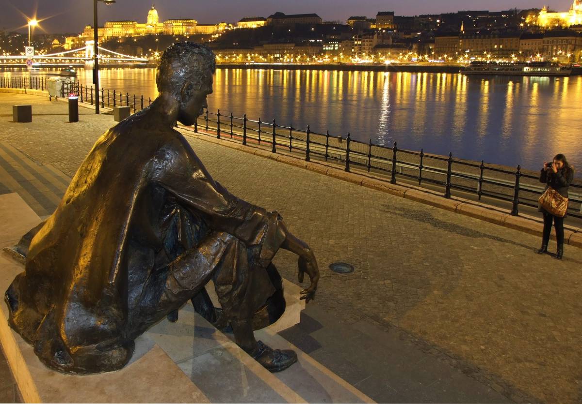 Egy turista fényképezi József Attila költő szobrát az új helyén a Duna-parton, a Kossuth Lajos tér déli oldalán.