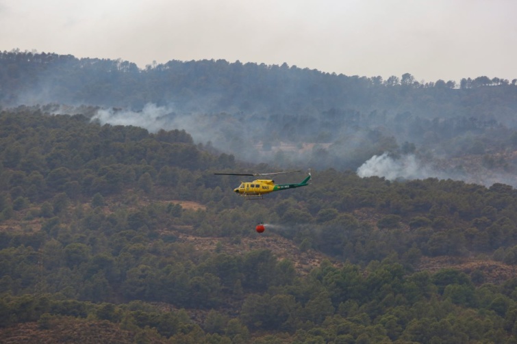 Helikopter dolgozik a 2022-es Los Guajares-i erdőtűz közelében.
