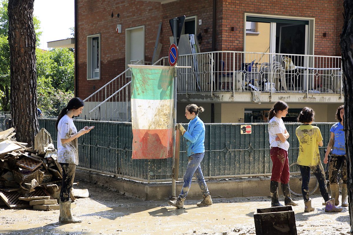 Olasz zászló mellett takarítást végző önkéntesek a közép-olaszországi Faenzában.