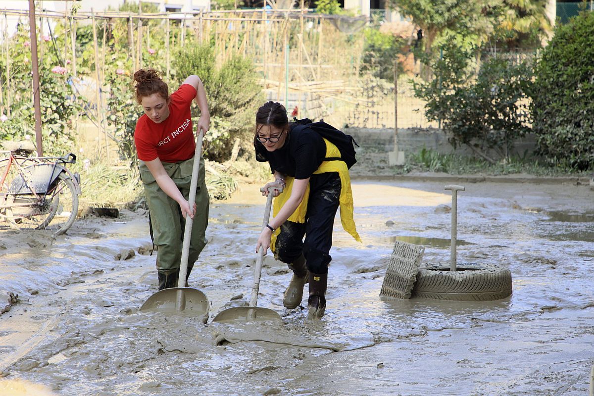 Sarat takarítanak el egy utcáról önkéntesek a közép-olaszországi Faenzában.