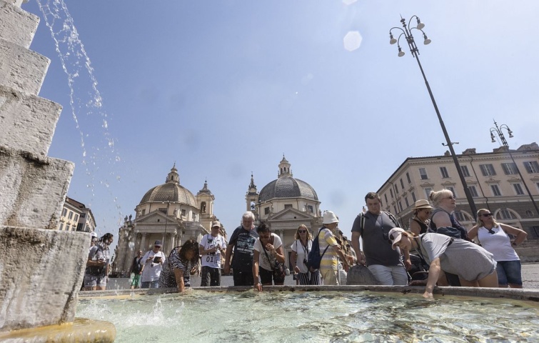 Turisták hűsítik magukat egy római szökőkút vizével 2022.08.08-án.