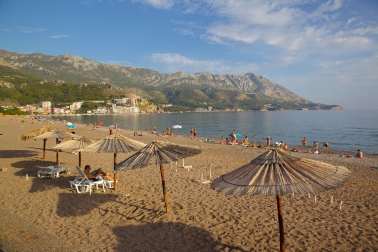 Napernyők, napozóágyak és strandolók egy budvai strandon.