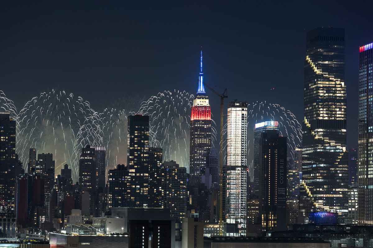 A kivilágított New York-i Empire State Building mellett tűzijáték