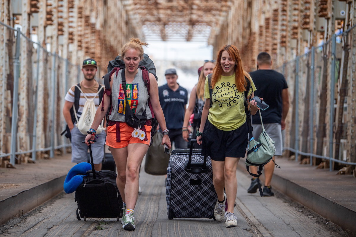 A 29. Sziget fesztiválra tartó fiatalok érkeznek a K-hídon az óbudai Hajógyári-szigetre