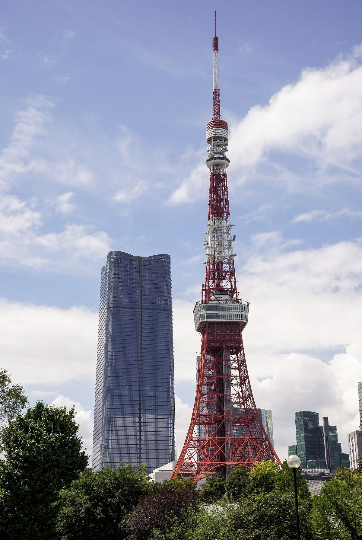 Az Azabudai Hills Mori JP Tower (b) a Tokiói toronnyal az előtérben.