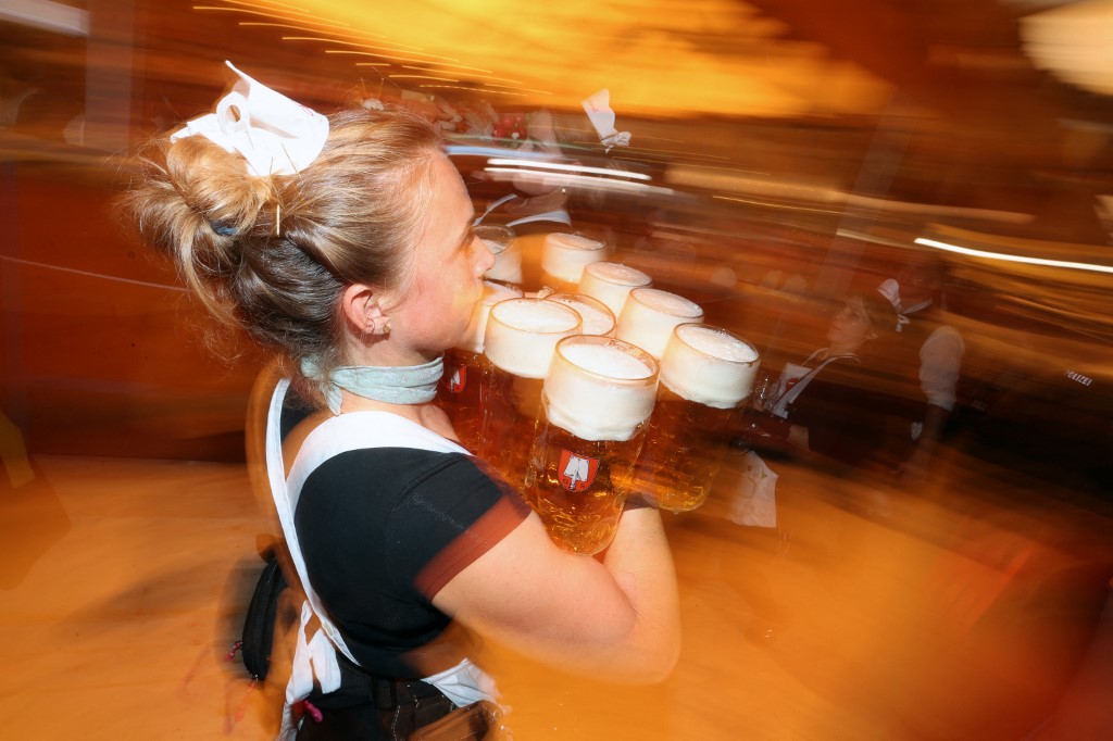 Egy pincérnő sört szolgál fel egy fesztiválsátorban.