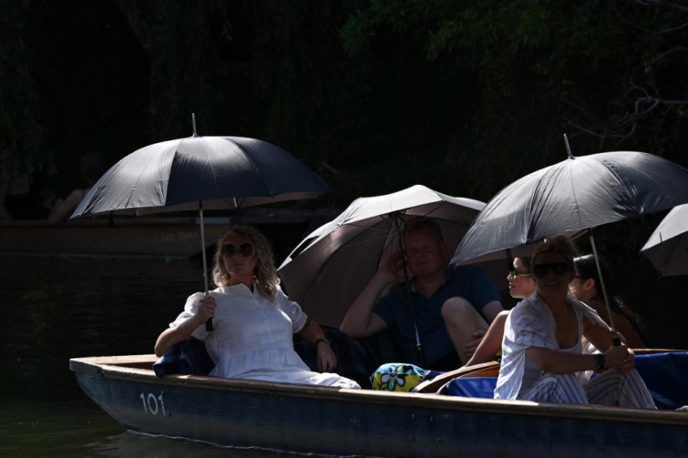 Emberek árnyékolják magukat a napsütés elől, miközben a Cam folyón csónakáznak a Londontól északra fekvő Cambridge-ben 2023. szeptember 9-én, a késő nyári kánikulában.
