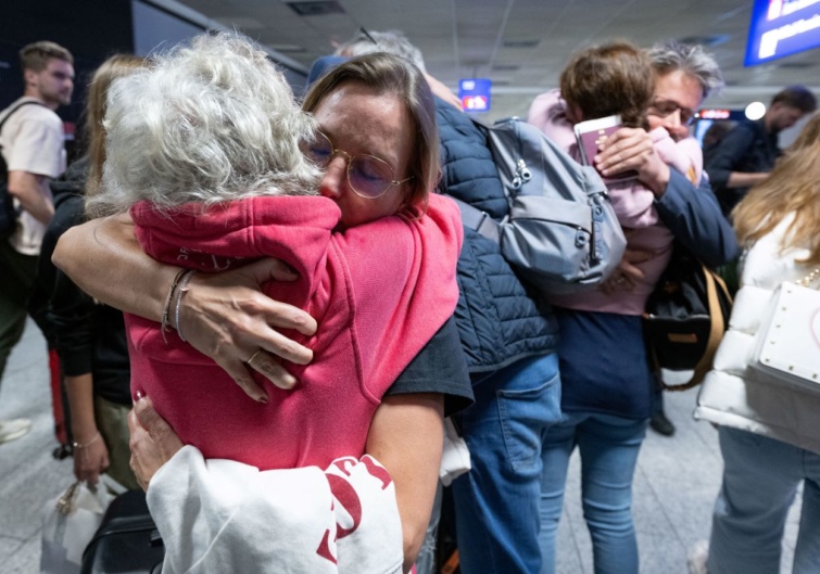 Rokonok és barátok ölelkeznek egy evakuációs járat leszállása után a frankfurti repülőtéren.