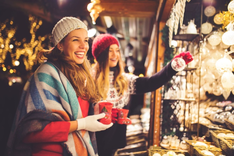 Karácsonyi díszeket válogat két nő egy adventi vásárban