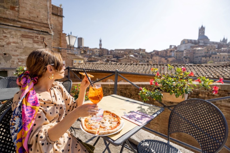 Valaki aperol spiccet iszik és pizzát eszik Sienna városában