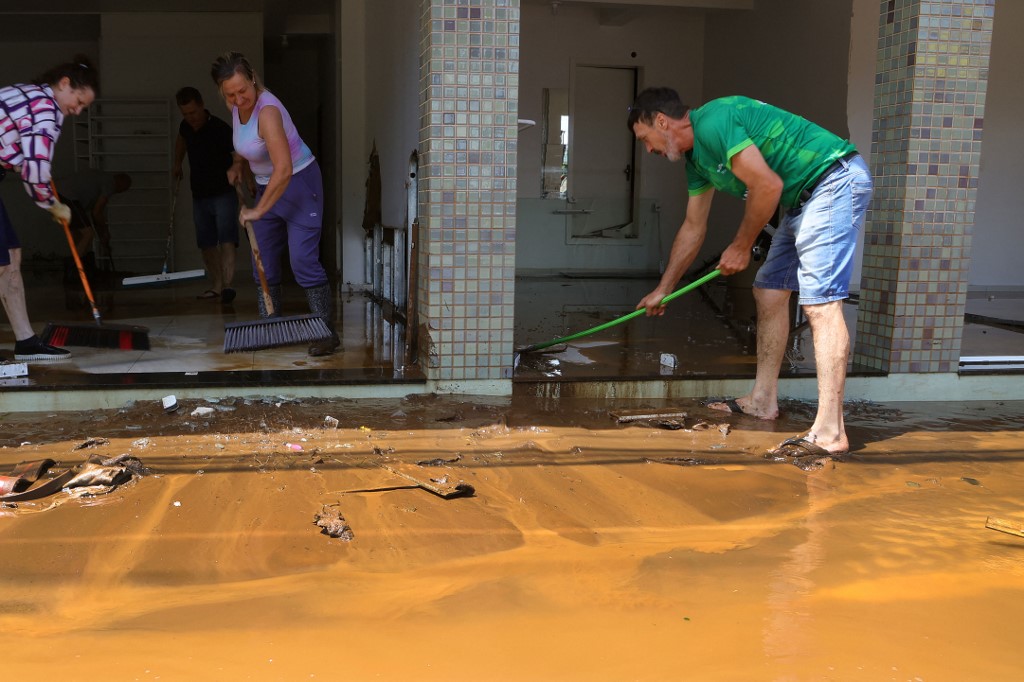 A helyi lakosok próbálják menteni az otthonaikat az áradás után