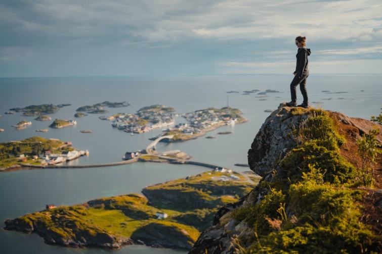 Valaki a norvégiai Nordlandban egy szikla szélén áll