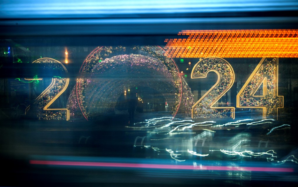 Egy busz halad el egy 2024-es újévi számokkal díszített újévi dekoráció mellett Moszkva központjában 2023. december 31-én,