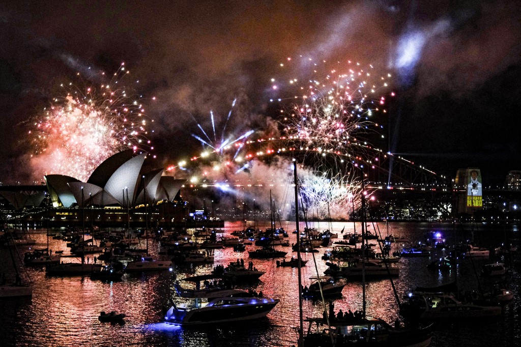 A sydneyi szilveszteri tűzijáték látványa, amelyet minden évben három órával éjfél előtt mutatnak be a Sydney Harbour Bridge körül az ausztráliai Sydneyben