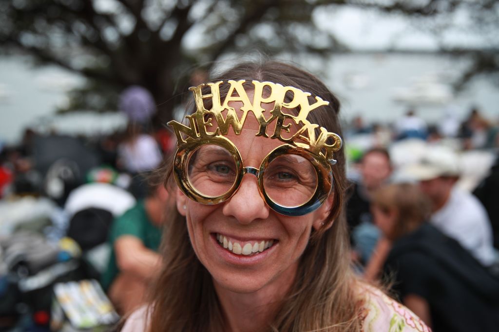 Egy nő Ausztráliában Happy New Year feliratú szemüvegben