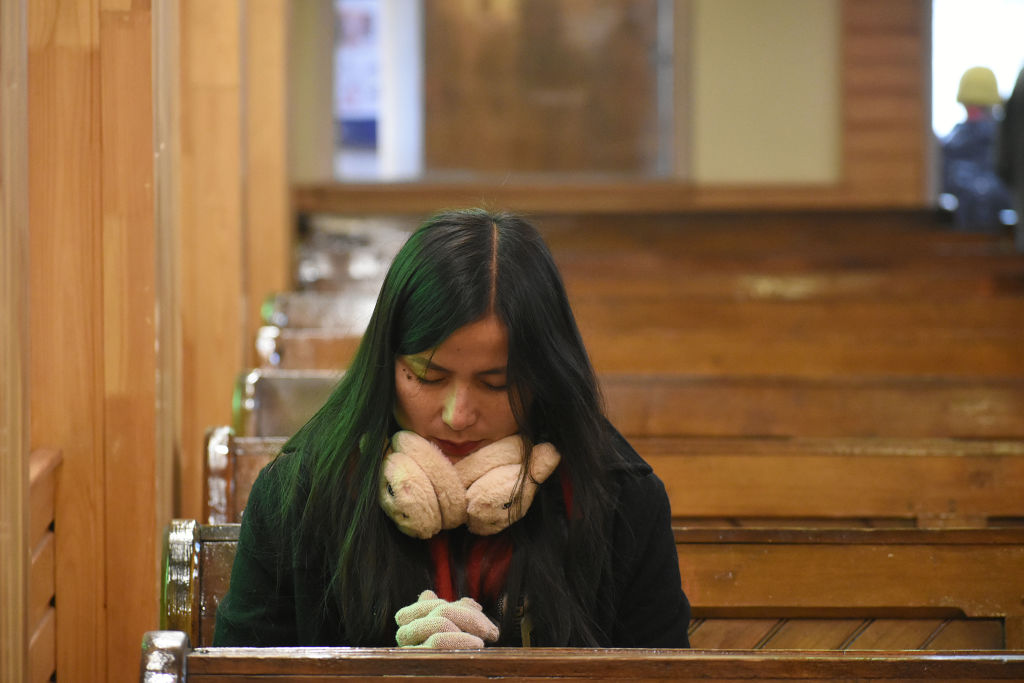 Egy nő imádkozik egy templomban a karácsonyi ünnepségek alatt Kasmírban, Indiában, 2023. december 25-én.