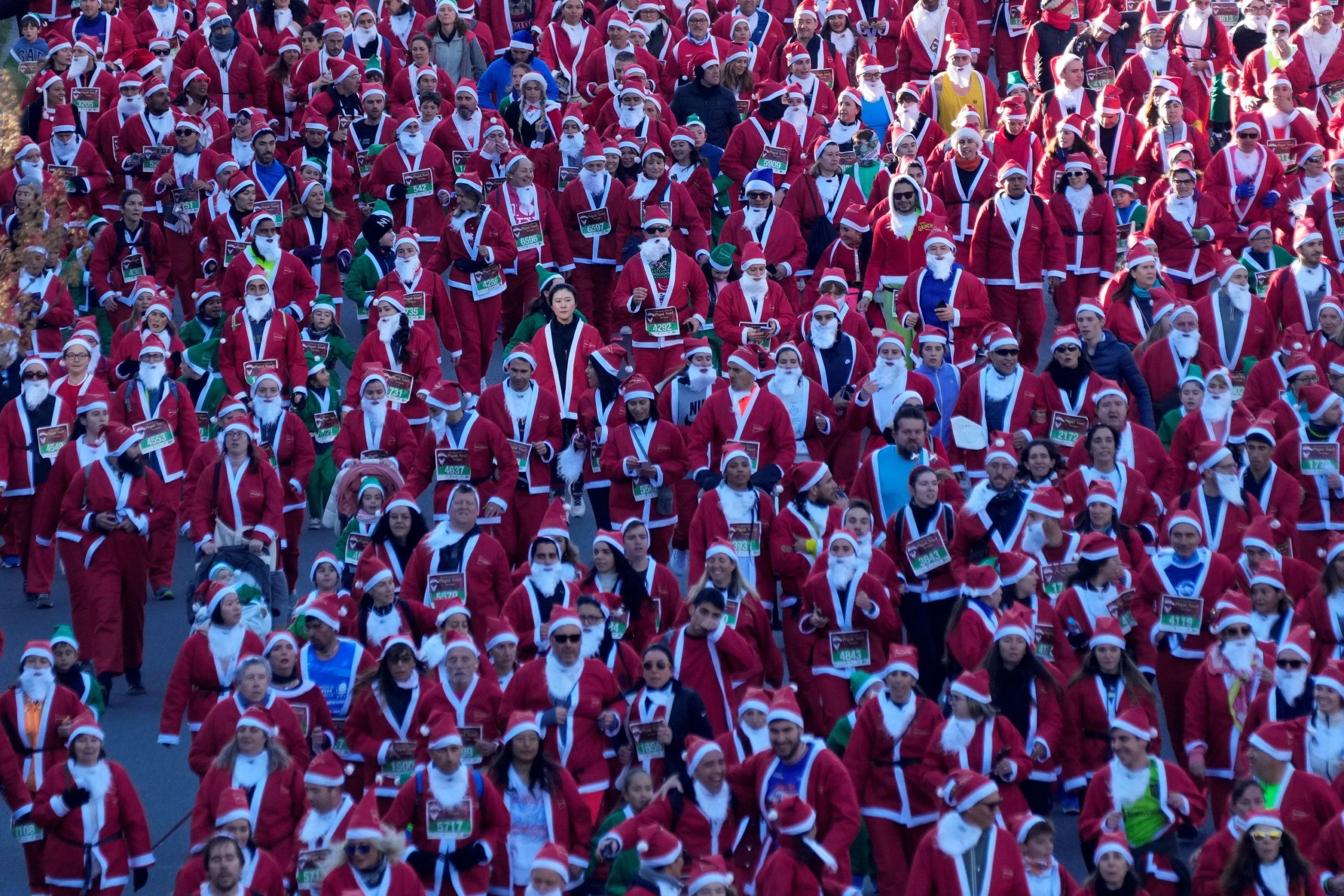 Mikulásruhát viselő résztvevők a Madrid belvárosában rendezett karácsonyi futáson.