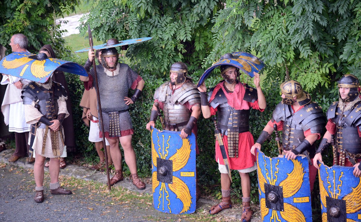 Gladiátornak öltözött résztvevők várakoznak az esőben a Savaria Történelmi Karneválon a szombathelyi Történelmi Témaparkban.