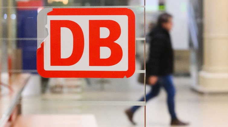 A Deutsche Bahn logója, a háttérben egy férfi.
