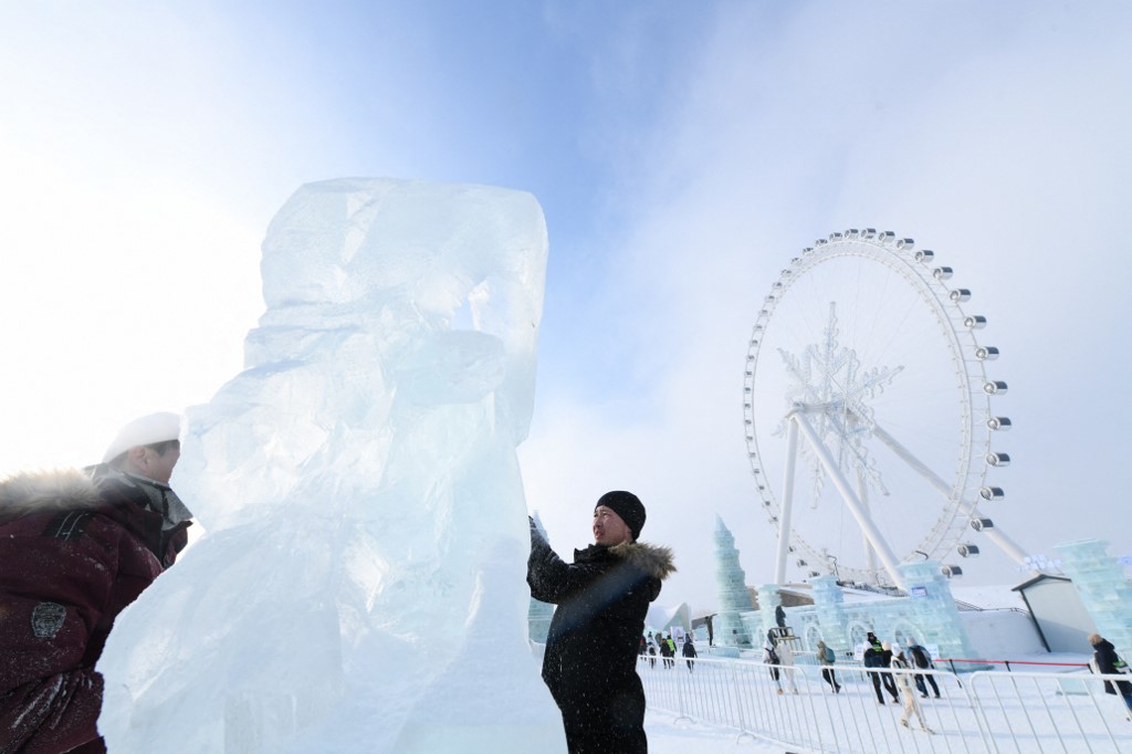 Versenyzők dolgoznak a saját, jégből készült alkotásaikon