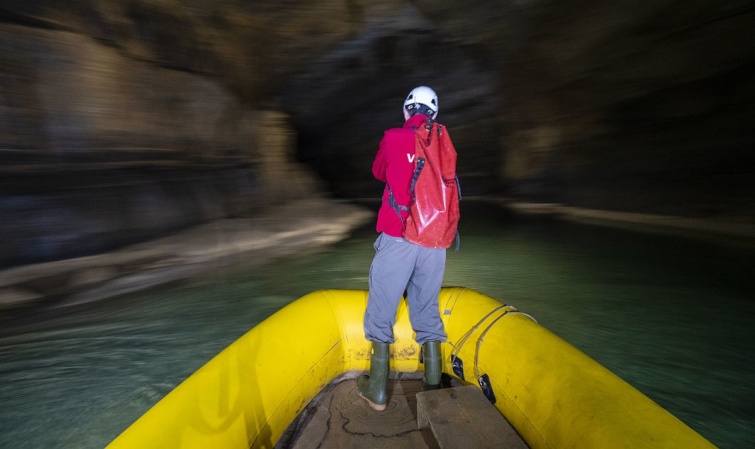 A Krizna-barlangban egy csónakban áll egy barlangász.