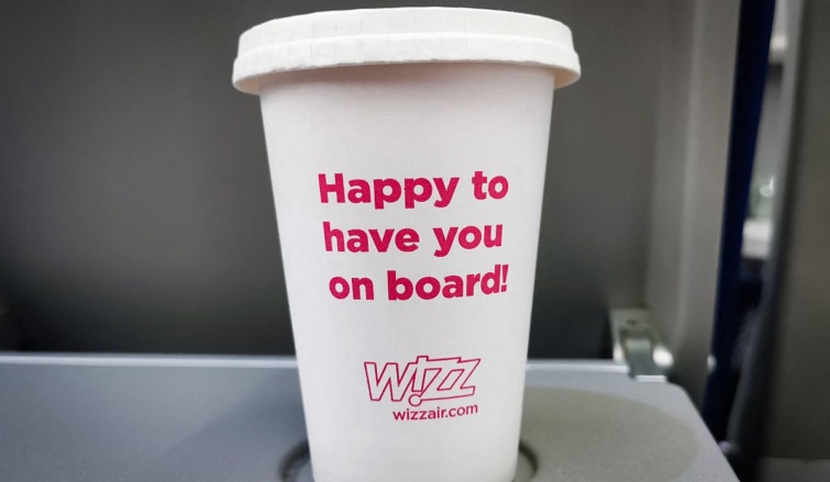 Egy Wizz Air feliratú pohár egy repülőgép fedélzetén.