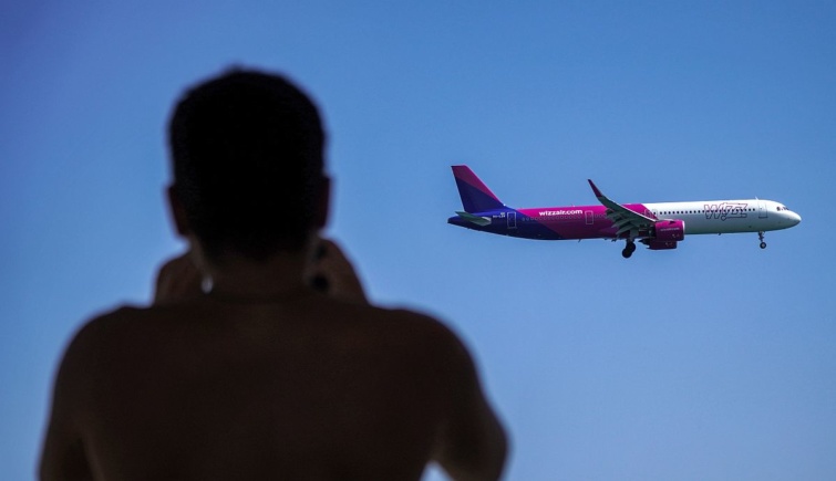 Egy férfi egy Wizz Air repülőgépet fotóz.