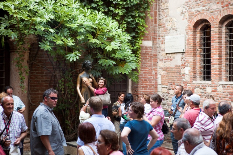 Turisták fogdossák a veronai Júlia-szobor mellét.