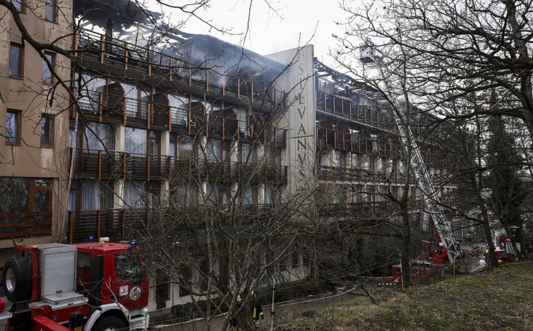hotel-silvanus-tuz - Startlap Utazás Tűzoltók oltják a kigyulladt visegrádi Hotel Silvanus épületét 2024. március 9-én. A hotel felső szintje teljes terjedelmében kiégett, a vendégek elhagyták az épületet.
