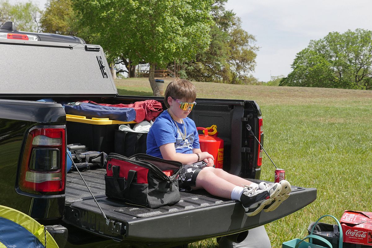 Egy autó platóján ülő gyerek várja a napfogyatkozást.
