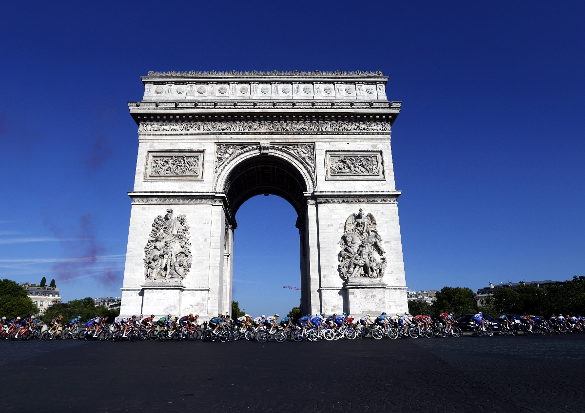 A párizsi diadalív elött a mezőny a 109. Tour de France francia országúti kerékpáros körverseny 21., a párizsi La Defence Arena és a Champs-Elysées közötti 116 kilométeres szakaszán 2022. július 24-én.