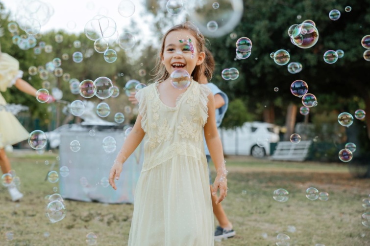 Kislány játszik buborékok között.