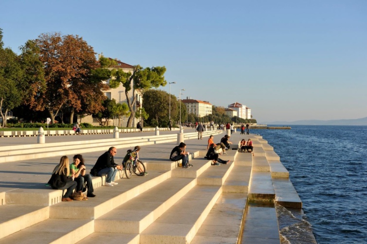 A tengeri zongoránál ücsörgő turistrák Zadarban.